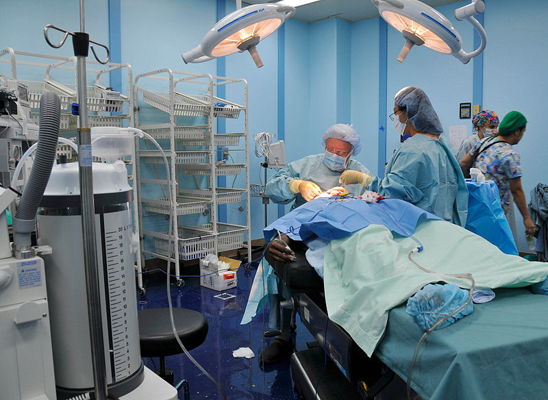 Surgeon and nurse operating on a patient