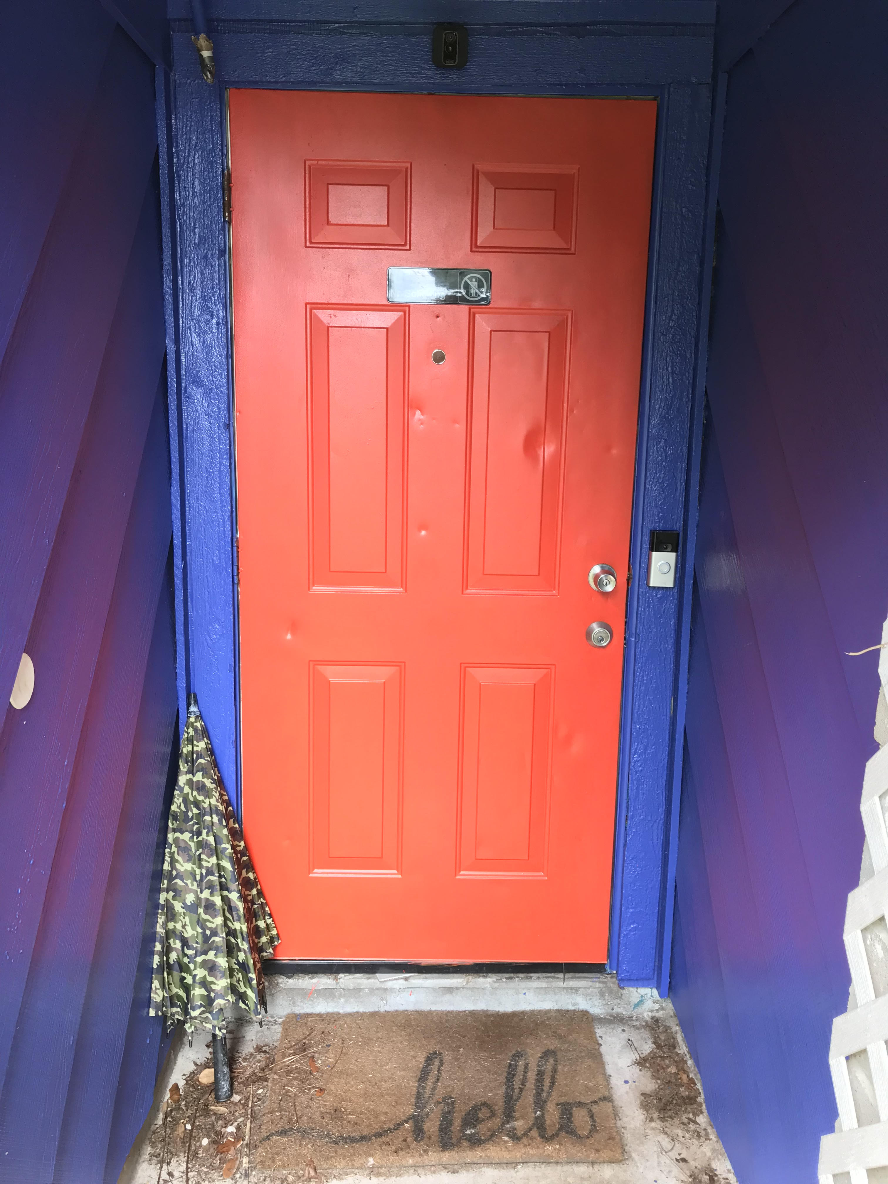 An entry door painted tomato red